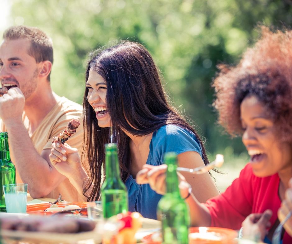 Picture of three adults enjoying backyard barbecue.
